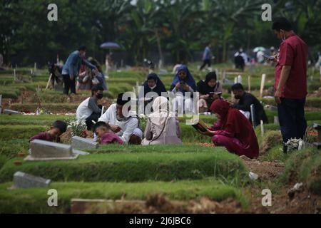 Eine Reihe von Bewohnern pilgern zu den Gräbern von Verwandten während der Feier des Eid Al-Fitr 1443 Hijri, am besonderen Grab für die Opfer von Covid-19, Rorotan Public Cemetery, Cilincing, Jakarta, Indonesien. Die diesjährige Eid al-Fitr-Feier wurde von einer Reihe von Muslimen genutzt, um Wallfahrten zu machen und für ihre Familien zu beten, die gemäß dem Covid-19-Protokoll begraben wurden. (Foto von Kuncoro Widyo Rumpoko/Pacific Press) Stockfoto