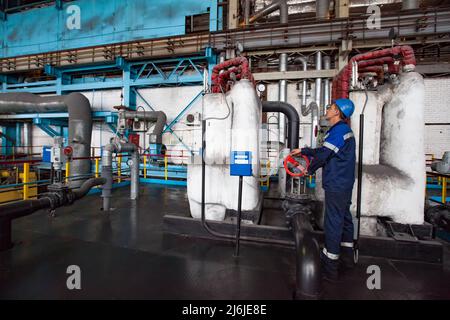 Rudny, Region Kostanay, Kasachstan-Mai 28 2012: Sokolovo-Sarbay Bergbau-und Verarbeitungsanlage Kraftwerk. Arbeiter nehmen ein Ventil der Ausrüstung. Stockfoto