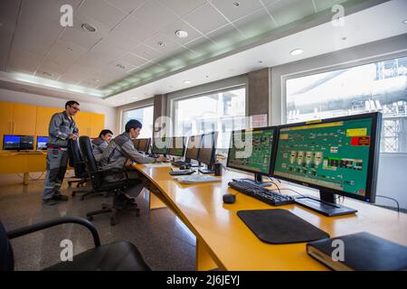 Mynaral, Kasachstan - April 23 2012: Kontrollzentrum für den Betrieb der Zementanlage von Jambyl. Computermonitore und asiatische man Operators (links). Stockfoto