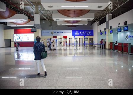 Aktau, Kasachstan - 21. Mai 2012: Aktau internationaler Flughafen modernes Terminal-Interieur. Passagiere an der Rezeption, rechts Stockfoto