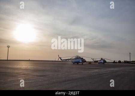 Aktau, Kasachstan - 21. Mai 2012: Internationaler Flughafen Aktau. Drei Hubschrauber auf schönem blauen Himmel mit wolkenbewölkter Hintergrund. Stockfoto