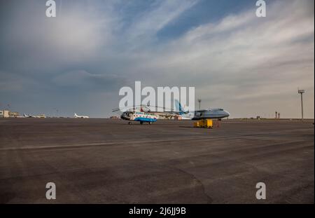 Aktau, Kasachstan - 21. Mai 2012: Internationaler Flughafen Aktau. Hubschrauber und Frachtjet am Boden. Stockfoto