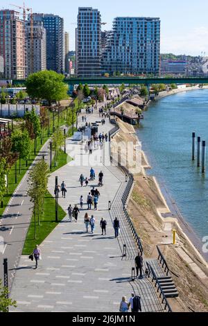 Belgrad, Serbien - April 25 2022 : Fußgänger, die am Fluss entlang an der Belgrade Waterfront spazieren, Luxusviertel mit Wohn- und Geschäftsbereichen Stockfoto