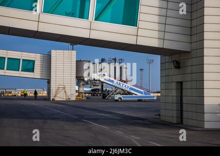 Aktau, Kasachstan - 21. Mai 2012: Internationaler Flughafen Aktau. Passagiergalerien und Gangway. Mobiler Gangway auf dem Feld. Stockfoto