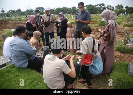 Eine Reihe von Bewohnern pilgern zu den Gräbern von Verwandten während der Feier des Eid Al-Fitr 1443 Hijri, am besonderen Grab für die Opfer von Covid-19, Rorotan Public Cemetery, Cilincing, Jakarta, Indonesien. Die diesjährige Eid al-Fitr-Feier wurde von einer Reihe von Muslimen genutzt, um Wallfahrten zu machen und für ihre Familien zu beten, die gemäß dem Covid-19-Protokoll begraben wurden. (Foto von Kuncoro Widyo Rumpoko/Pacific Press/Sipa USA) Stockfoto