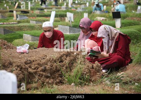 Eine Reihe von Bewohnern pilgern zu den Gräbern von Verwandten während der Feier des Eid Al-Fitr 1443 Hijri, am besonderen Grab für die Opfer von Covid-19, Rorotan Public Cemetery, Cilincing, Jakarta, Indonesien. Die diesjährige Eid al-Fitr-Feier wurde von einer Reihe von Muslimen genutzt, um Wallfahrten zu machen und für ihre Familien zu beten, die gemäß dem Covid-19-Protokoll begraben wurden. (Foto von Kuncoro Widyo Rumpoko/Pacific Press/Sipa USA) Stockfoto