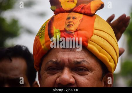 2. Mai 2022, Rajpur Sonarpur, Westbengalen, Indien: Ein Unterstützer der Bharatiya Janata Party (BJP), der regierenden politischen Partei Indiens, nimmt an einer Demonstration in Kalkutta Teil, die einen Turban mit dem Image von Premierminister Narendra Modi trägt, um gegen die anhaltende Gewalt im ostindischen Bundesstaat Westbengalen zu protestieren. (Bild: © Sankhadeep Banerjee/ZUMA Press Wire) Stockfoto