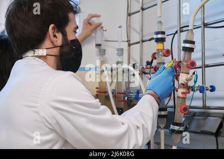 Zwei Forscher, die in einem Labor mit Wirbelschichtreaktoren arbeiten. Stockfoto