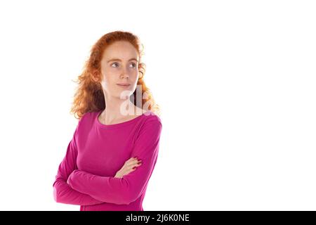 Rothaarige junge Frau trägt ein rosa T-Shirt isoliert auf weißem Hintergrund Stockfoto