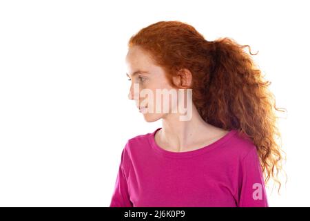 Rothaarige junge Frau trägt ein rosa T-Shirt isoliert auf weißem Hintergrund Stockfoto