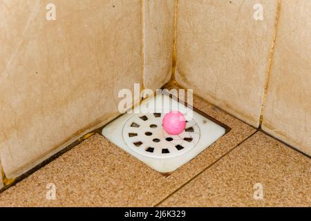 Abflussloch im Bad mit braunem Fliesenboden Stockfoto