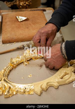 Anwendung von Blattgold auf einen Rahmen. Vergoldungsverfahren. Stockfoto