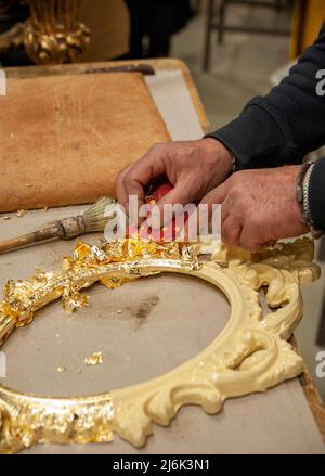 Anwendung von Blattgold auf einen Rahmen. Vergoldungsverfahren. Stockfoto