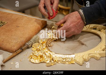 Anwendung von Blattgold auf einen Rahmen. Vergoldungsverfahren. Stockfoto