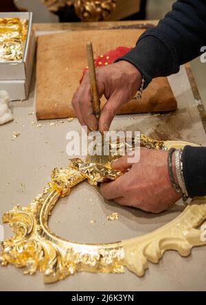 Anwendung von Blattgold auf einen Rahmen. Vergoldungsverfahren. Stockfoto