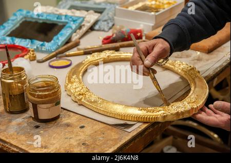 Anwendung von Blattgold auf einen Rahmen. Vergoldungsverfahren. Stockfoto
