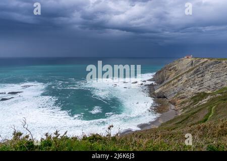 Ein Blick auf den Leuchtturm auf den Klippen von Cabo Vidio unter einem bewölkten und stürmischen Himmel Stockfoto