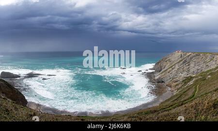 Ein Blick auf den Leuchtturm auf den Klippen von Cabo Vidio unter einem bewölkten und stürmischen Himmel Stockfoto