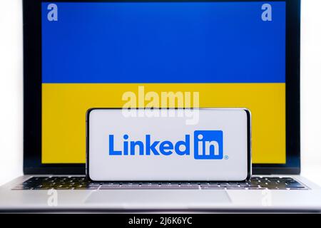 LinkedIn Firmenlogo auf Smartphone und ukrainische Flagge auf dem Hintergrund. Konzept. Stafford, Großbritannien, 20. März 2022 Stockfoto