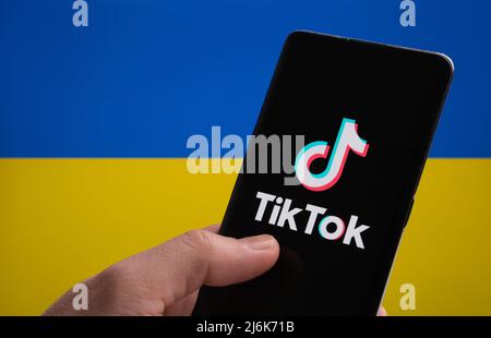 TikTok App-Logo auf dem Smartphone und ukrainische Flagge auf dem Hintergrund. Konzept. Stafford, Großbritannien, 20. März 2022 Stockfoto