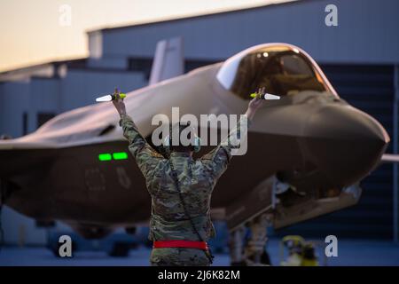 Vermont Air National Guard Base, USA. 2.. Mai 2022. Kredit: TSgt. Richard Mekkri/US Air Force/Alamy Live NewsBurlington, Vereinigte Staaten. 02. Mai 2022. Ein Chef der US-Luftstreitkräfte, der dem 158.-Kampfflügel zugewiesen wurde, signalisiert einem F-35A Lightning II-Kampfflugzeug ein Taxi, während es sich auf den Abflug vom Vermont Air National Guard Base am 2. Mai 2022 in South Burlington, Vermont, vorbereitet. Das Flugzeug wird zur Spangdahlem Air Base, Deutschland, zurückgebracht, um der NATO Enhanced Air Policing Mission beizutreten. Quelle: Planetpix/Alamy Live News Stockfoto