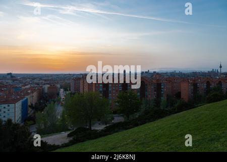 Ein herrlicher, warmer Sonnenuntergang über der Skyline von Madrid mit Blick auf die Bergkette am Horizont, von einem Aussichtspunkt im Osten der Stadt aus gesehen. Stockfoto