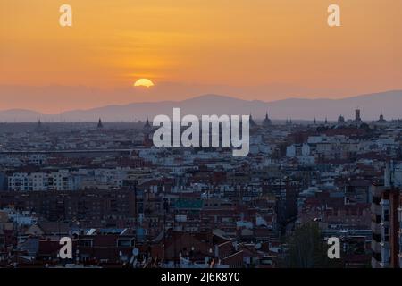 Ein herrlicher, warmer Sonnenuntergang über der Skyline von Madrid mit Blick auf die Bergkette, Sierra de Guadarrama am Horizont, von las siete tetas aus gesehen Stockfoto