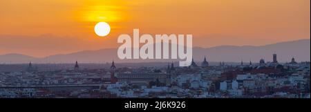 Ein herrlicher, warmer Sonnenuntergang über der Skyline von Madrid mit Blick auf die Bergkette, Sierra de Guadarrama am Horizont, von las siete tetas aus gesehen Stockfoto