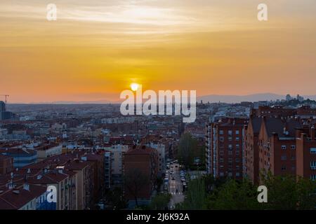 Ein herrlicher, warmer Sonnenuntergang über der Skyline von Madrid mit Blick auf die Bergkette, Sierra de Guadarrama am Horizont, von las siete tetas aus gesehen Stockfoto