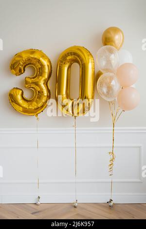 Festliche Heliumballons in Gold und Weiß, Nummer 30 Stockfoto