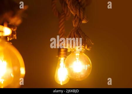 Edison Glühbirne, Vintage hängende Edison Glühbirne über dunklem Hintergrund. Gelbe Lichter mit Hintergrund für den Kopierbereich. Stockfoto