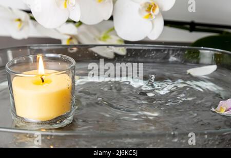 Foto einer Kerze mit Regen, Wassertropfen, die das Feuer löschen, Wasserspritzer Stockfoto