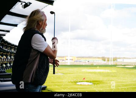 Senior Mann spielt Golf in moderner Golfanlage Stockfoto