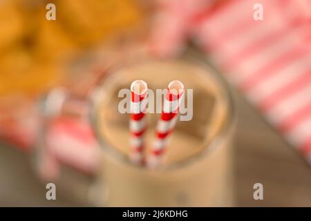 Nahaufnahme von Trinkhalmen in einer Glasschale auf einem Holztisch - Studioaufnahme Stockfoto