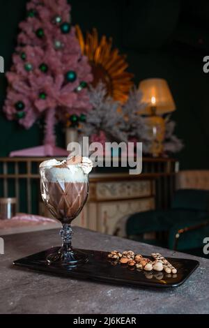 Süßer Milchshake mit Creme und Zimt in einem Glas. Stockfoto