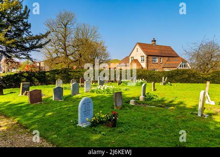 Kirchhof mit Grabsteinen in der St. Margaret of Antioch Parish Church, Bygrave Village, Hertfordshire, Großbritannien Stockfoto