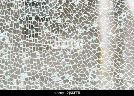 Gebrochenes gehärtetes Glas einfache abstrakte Hintergrundtextur, zerbrochene Glasfenster Objektstruktur Makro, Detail, extreme Nahaufnahme, niemand. crac beschädigt Stockfoto