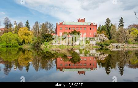 Rote, neugotische Burg in Klasterec nad Ohri, Tschechien, spiegelt sich im Fluss Stockfoto
