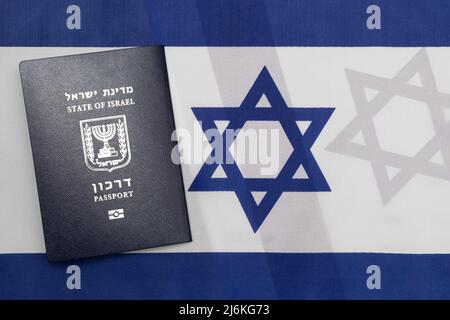 Internationaler biometrischer Pass des Staates Israel (Darkon) auf israelischer Flagge. Israel Staatsbürgerschaft Reisekonzept. Stockfoto