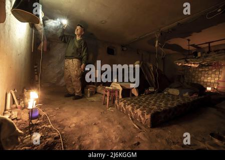 Charkiw, Ukraine. 02.. Mai 2022. Sasha Zolotov, 55, erledigt einige Aufgaben im Keller, der als Bombenschutz für sein Wohnhaus nahe der russischen Grenze in Charkiw, Ukraine, am Montag, den 2. Mai 2022 genutzt wurde. Zolotows Wohnung wurde zweimal von russischen Artilleriebällen getroffen, die nur wenige Wochen auseinander lagen. Die Wohnung brannte nieder, und alles, was er übrig hatte, waren die Kleidung, die er trug, und sein Reisepass. Zolotov lebt jetzt im Keller gedreht Bombenschutz. Foto von Ken Cedeno/UPI Credit: UPI/Alamy Live News Stockfoto