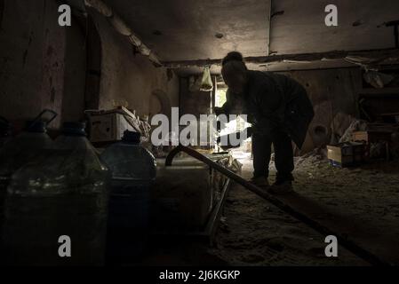 Charkiw, Ukraine. 02.. Mai 2022. Ljudmyla Mikhailivna Kiritschenko, 75, vorbereitet Mahlzeiten für andere Bewohner im Keller, der als Bombenschutz für ihr Wohnhaus, etwa 30 Kilometer von der russischen Grenze entfernt, in Charkiw, Ukraine, am Montag, den 2. Mai 2022, genutzt wurde. Kirichenkos wohnt jetzt im Keller, da es keinen Strom gibt und die Aufzüge nicht funktionieren. Seit dem ersten Kriegstag am 24. Februar wandert sie nie mehr als 20 Meter vom Keller entfernt. Foto von Ken Cedeno/UPI Credit: UPI/Alamy Live News Stockfoto