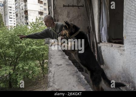 Charkiw, Ukraine. 02.. Mai 2022. Sasha Zolotov, 55, früher im Militär, hängt am Montag, den 2. Mai 2022, mit seinem deutschen Schäferhund „Krokodilhund“ in seiner alten Wohnung nahe der russischen Grenze in Charkiw, Ukraine. Zolotows Wohnung wurde zweimal getroffen, nur wenige Wochen auseinander. Die Wohnung brannte ab und alles, was er übrig hatte, waren die Kleidung, die er trug, und sein Reisepass. Zolotov lebt jetzt im Keller gedreht Bombenschutz. Foto von Ken Cedeno/UPI Credit: UPI/Alamy Live News Stockfoto