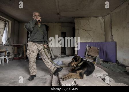 Charkiw, Ukraine. 02.. Mai 2022. Sasha Zolotov, 55, früher im Militär, hängt am Montag, den 2. Mai 2022, mit seinem deutschen Schäferhund „Krokodilhund“ in seiner alten Wohnung nahe der russischen Grenze in Charkiw, Ukraine. Zolotows Wohnung wurde zweimal getroffen, nur wenige Wochen auseinander. Die Wohnung brannte ab und alles, was er übrig hatte, waren die Kleidung, die er trug, und sein Reisepass. Zolotov lebt jetzt im Keller gedreht Bombenschutz. Foto von Ken Cedeno/UPI Credit: UPI/Alamy Live News Stockfoto