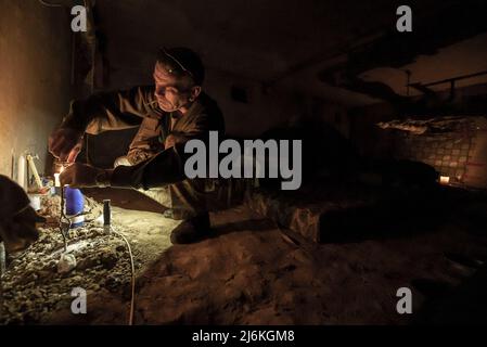 Charkiw, Ukraine. 02.. Mai 2022. Sasha Zolotov, 55, erledigt einige Aufgaben im Keller, der als Bombenschutz für sein Wohnhaus nahe der russischen Grenze in Charkiw, Ukraine, am Montag, den 2. Mai 2022 genutzt wurde. Zolotows Wohnung wurde zweimal von russischen Artilleriebällen getroffen, die nur wenige Wochen auseinander lagen. Die Wohnung brannte nieder, und alles, was er übrig hatte, waren die Kleidung, die er trug, und sein Reisepass. Zolotov lebt jetzt im Keller gedreht Bombenschutz. Foto von Ken Cedeno/UPI Credit: UPI/Alamy Live News Stockfoto