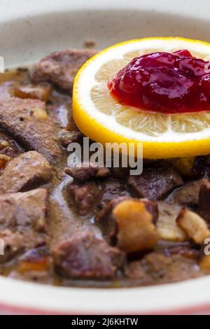 Wildgulasch mit Zitrone und Preiselbeeren Stockfoto