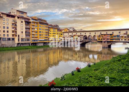 Schöner Blick auf die Brücke Ponte Vecchio mit einem Corridoio Vasariano auf den Arno in Florenz bei Sonnenuntergang. Toskana, Italien Stockfoto