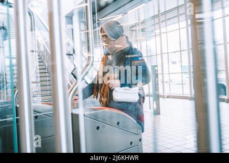 Ältere Frau ermöglicht Fahrkarte, um den Zug zu nehmen Stockfoto