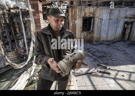 Charkiw, Ukraine. 02.. Mai 2022. Oleg Petjuschenko, 46, zeigt die Überreste der russischen Artillerie in der Nähe seines Wohnhauses nahe der russischen Grenze in Charkow, Ukraine, Montag, 2. Mai 2022. Petjuschenko hat im Krieg im Donbass seit 2014 drei Rotationen durchgeführt, zweimal schwer verletzt und ist jetzt schockiert. Am 1. Mai wurde das Gebiet von russischer Artillerie beschossen und er hinkt nun davon ab, mit einem Granatsplitter über seinem rechten Schienbeinchen getroffen zu werden. Foto von Ken Cedeno/UPI Credit: UPI/Alamy Live News Stockfoto