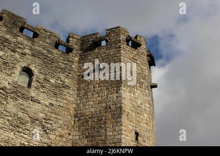 Sonniger alter Steinschlossturm gegen einen wolkig blauen Himmel (Gravensteen, Gent, Belgien) Stockfoto