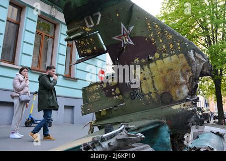 Kiew, Ukraine - am 02. Mai 2022 inspiziert Ein Paar einen Splitter eines russischen Militärflugzeugs SU-25, das vom ukrainischen Militär in der Region Kiew zerstört wurde. Russland marschierte am 24. Februar 2022 in die Ukraine ein und löste damit den größten militärischen Angriff in Europa seit dem Zweiten Weltkrieg aus Stockfoto